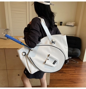 Detailed view of white athletic tote bag with tennis racket slot and exterior flap pocket