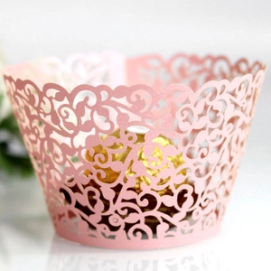 Pink laser-cut filigree cupcake wrappers with elegant vine pattern for party decoration
