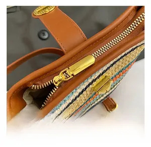 Macro shot of colorful woven bucket bag featuring gold hardware and brown leather trim