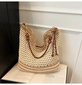 Close-up of woven tote bag with wooden beads decoration and brown leather strap detail