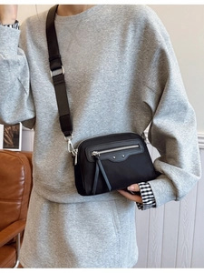 Sac bandoulière chic en nylon noir avec large sangle et accents métalliques argentés