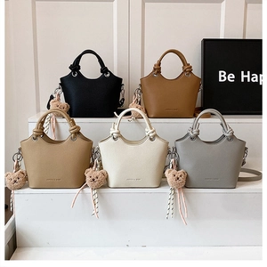 Detail of five textured leather bucket bags with knot handles and cute bear charms