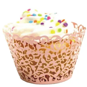 Pink laser-cut cupcake wrapper with vine patterns and decorated pastry on white background