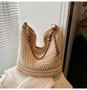 Detail of bohemian hollow-out tote bag featuring wooden beads and gold ring handle