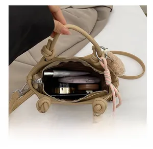 Detail shot of the interior capacity of the beige bucket bag with makeup items inside