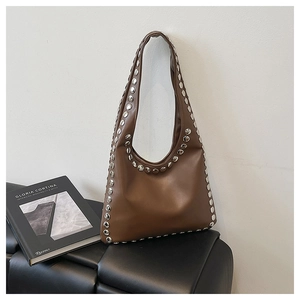 Detailed macro view of brown leather Hobo bag with silver metal rivets and matte finish