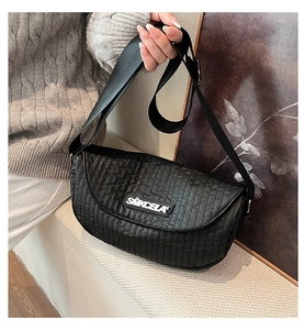 Detail view of black quilted crossbody bag with textured fabric and SMKCELA logo