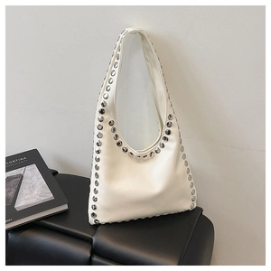 Detailed macro view of white PU leather hobo bag with silver rivet studs on a dark stool