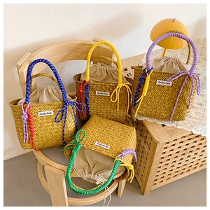 Detail of four colorful straw bucket bags with cotton drawstring liners on a chair