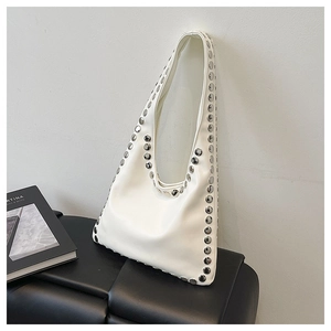 Detail view of white minimalist shoulder bag featuring polished silver metal studs decoration