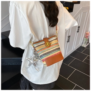 Colorful woven crossbody bucket bag with brown leather details and star charm
