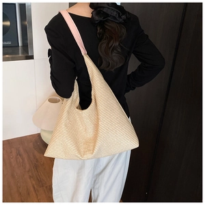 Dettaglio della trama intrecciata beige e del cinturino in pelle rosa della borsa hobo