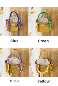 Detail of woven straw bucket bag with colorful handles and drawstring cotton liner