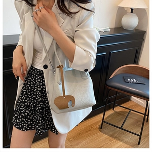 Sac seau gris clair chic avec texture litchi et détail de breloque éléphant