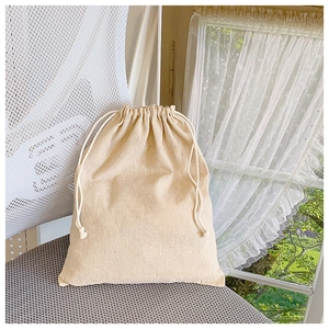 Detail of a beige canvas drawstring inner pouch with natural cotton rope closure