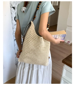 Detail der handgehäkelten Netztasche mit braunem Seilriemen und bunten Holzperlen-Dekor