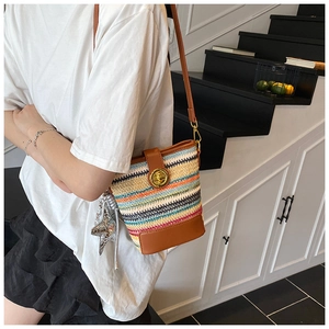 Close-up of bohemian woven bucket bag featuring brown leather details and a gold metal lock