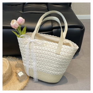 Detailed lace crochet tote bag with woven straw handles and a delicate bow decoration