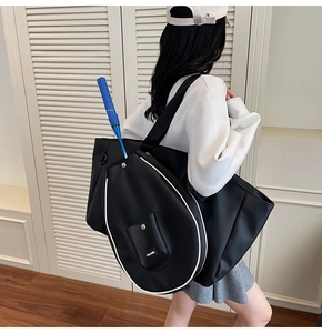 Detail of black sports tote bag with exterior badminton racket pocket and white piping