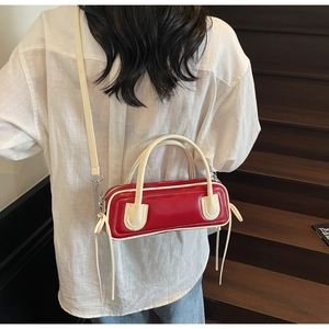 Detail of red and white bowling bag with sleek leather finish and retro straps
