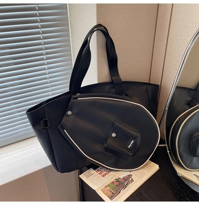 Detail of black faux leather tote with matching tennis racket cover and white piping