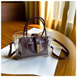 Detail view of transparent PVC tote bag with burgundy inner pouch and gold lock