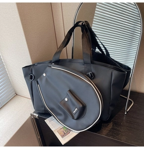 Detail of black large capacity tote bag and matching pouch with contrast white piping