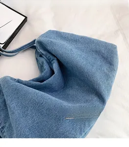 Close-up of blue denim tote bag showing detailed twill fabric texture and spacious design