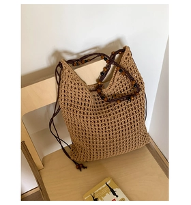 Detailed macro view of the hand-woven khaki mesh texture and boho wooden beads on tote bag
