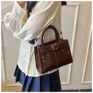 Détails de sac à main marron foncé avec boucle métallique et rivets argentés