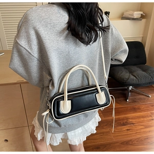 Close-up of black and white contrast leather crossbody bag with drawstring details
