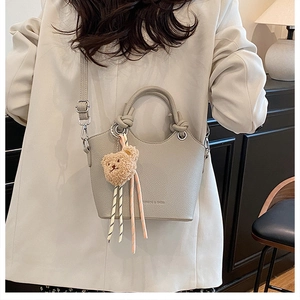 Detailed back view of a light gray pebble leather bucket bag with a knotted handle