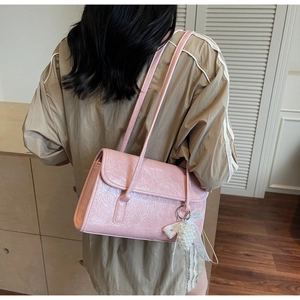 Pink pleated shoulder bag featuring a delicate pearl bow charm and long double straps