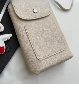 Detail of beige litchi grain leather crossbody phone bag with front card slot and snap