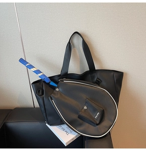 Detail of black leather badminton tote bag with a racket compartment and white piping