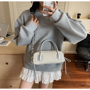 Mirror selfie showing the minimalist beige handbag styled with a casual everyday outfit