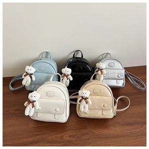 Detailed close-up of colorful mini backpacks in textured faux leather with bear charms