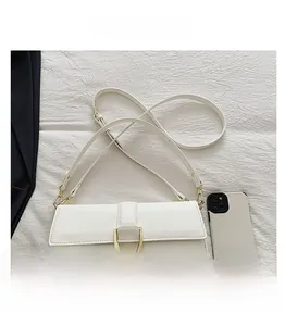 Détail d'un sac à bandoulière blanc avec boucle en D dorée sur fond de tissu blanc