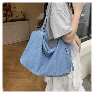 Close-up of blue denim tote bag with metal buttons and washed texture detail