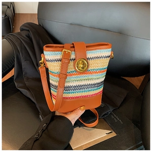 Detailed close-up of colorful woven bucket bag with leather trim and gold twist lock