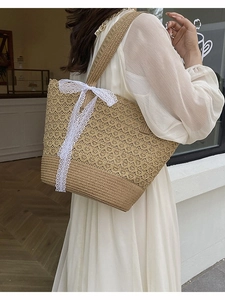 Straw tote bag with white lace ribbon bow for summer beach vacation and shopping