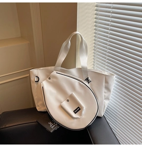 Close-up of white tote bag set with wide shoulder strap and Grey-white label detail