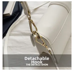 Gros plan du crochet doré amovible et de la boucle à ressort du sac à bandoulière blanc