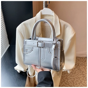 Détail du sac bandoulière argenté avec fini métallique et boucle décorative chic