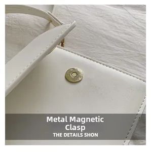 Gros plan détaillé d'un sac en cuir blanc avec boucle magnétique ronde en métal