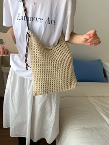 Bohemian beige crochet knit tote bag with drawstring closure worn by a model