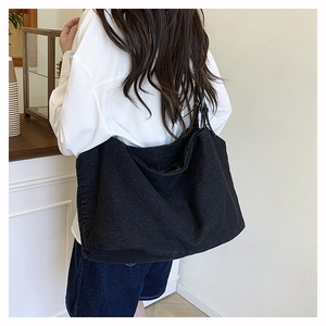 Close-up of large black washed canvas tote bag showing heavy texture and shoulder strap