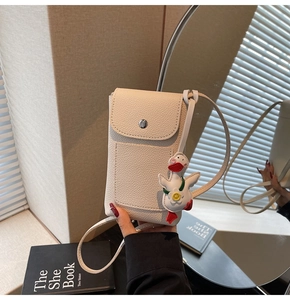 Close-up of beige litchi pattern phone bag featuring a silver buckle and cute duck charm