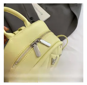 Detail of yellow quilted backpack with dual metal zippers and star charm accessory