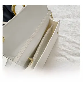 Détail de l'intérieur du sac en similicuir blanc avec compartiment et fermeture dorée